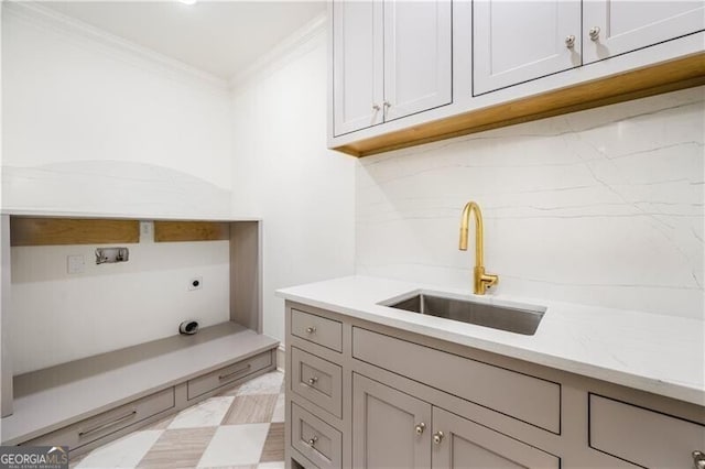 washroom with cabinets, washer hookup, crown molding, hookup for an electric dryer, and sink