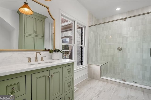 bathroom with vanity, tasteful backsplash, and a shower with door