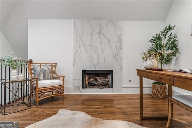 sitting room with a high end fireplace and hardwood / wood-style floors