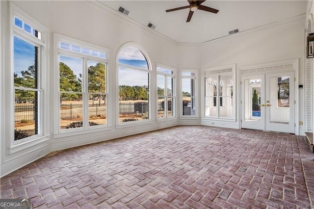 unfurnished sunroom with french doors, ceiling fan, and a wealth of natural light