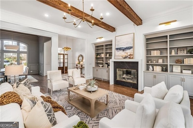 living room featuring ornamental molding, beamed ceiling, dark wood-type flooring, and a fireplace