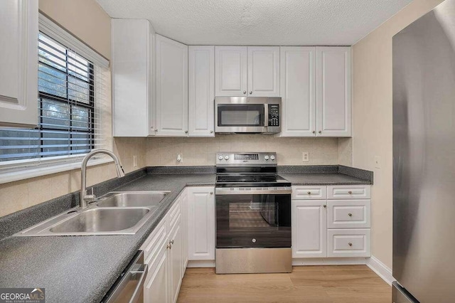 kitchen with backsplash, stainless steel appliances, and white cabinets