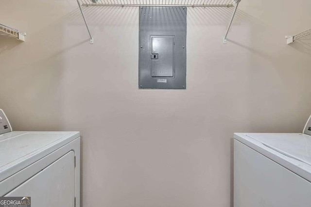 laundry area with electric panel and washing machine and clothes dryer