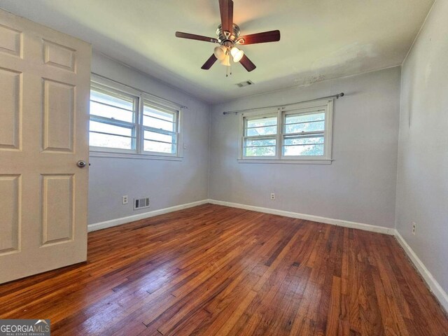 unfurnished room featuring ceiling fan and dark hardwood / wood-style flooring