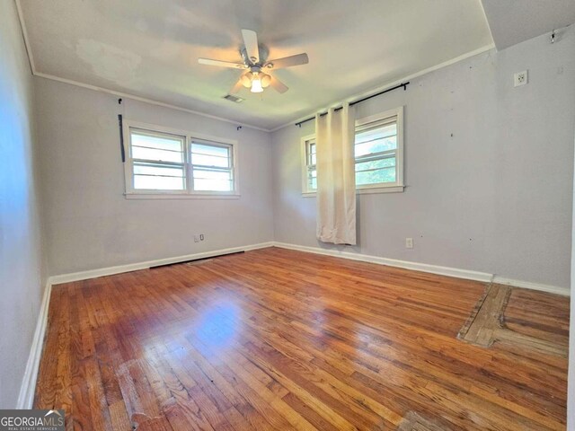 empty room with ornamental molding, hardwood / wood-style flooring, and ceiling fan