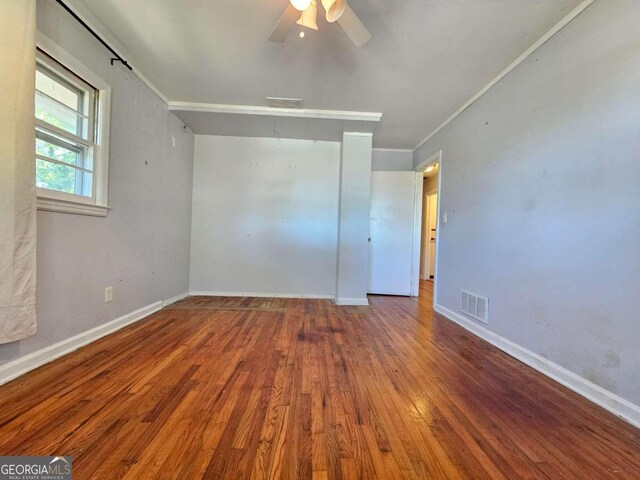 empty room featuring crown molding, hardwood / wood-style flooring, and ceiling fan