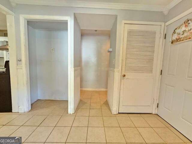 hall featuring crown molding and light tile patterned floors