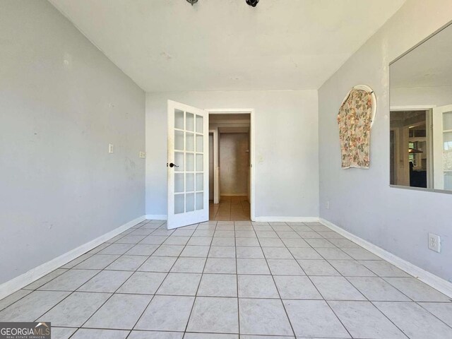 tiled spare room with french doors