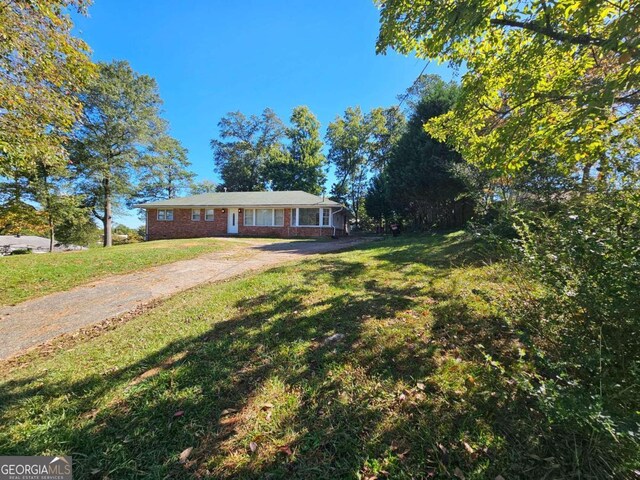 ranch-style home featuring a front lawn