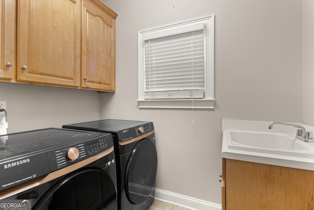 washroom with sink, light tile patterned flooring, independent washer and dryer, and cabinets