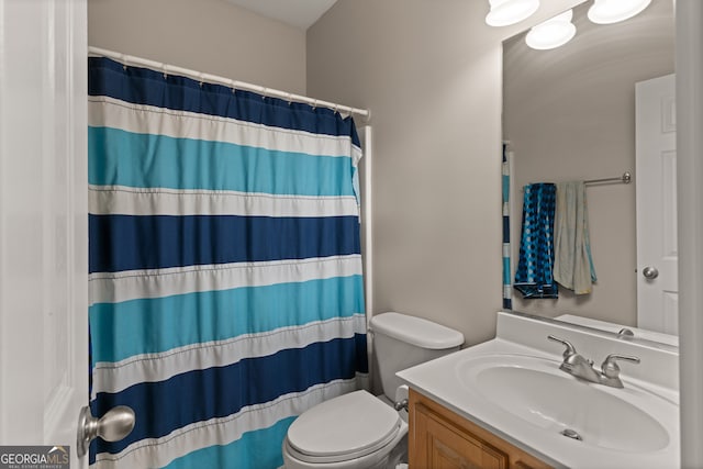 bathroom featuring vanity, toilet, and walk in shower