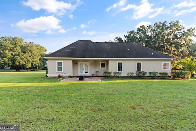 rear view of house with a patio area, french doors, and a yard