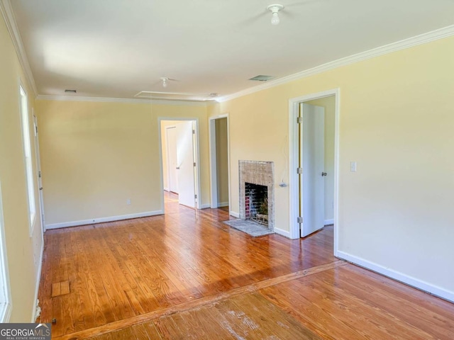 unfurnished living room featuring hardwood / wood-style flooring and ornamental molding