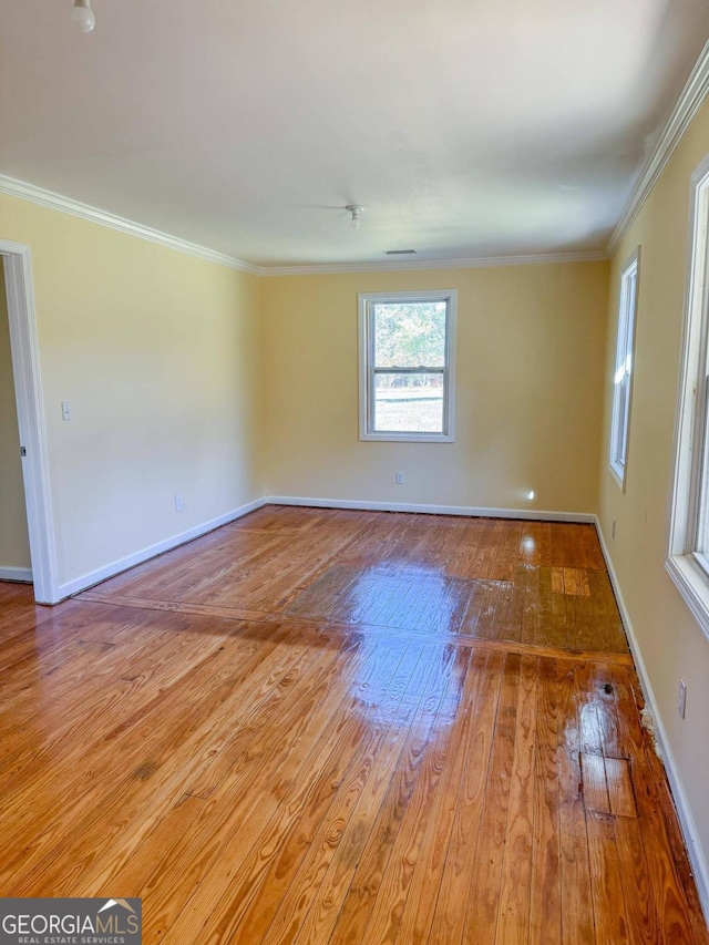 spare room with light hardwood / wood-style flooring and crown molding