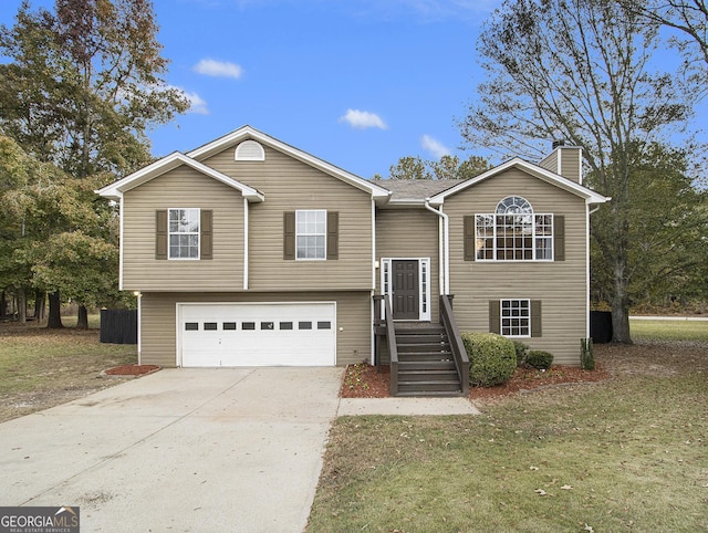 split foyer home featuring a garage and a front lawn