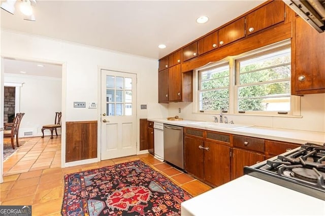 kitchen with crown molding, sink, light tile patterned floors, and stainless steel dishwasher