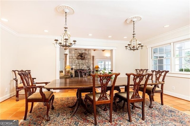 dining room featuring ornamental molding, tile patterned floors, plenty of natural light, and a stone fireplace