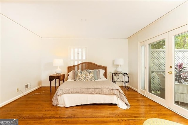 bedroom featuring access to exterior and hardwood / wood-style flooring