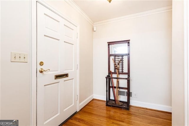 entryway featuring crown molding and hardwood / wood-style floors