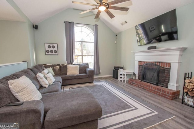 50 Carthedge Trce, Newnan, GA 30263 - living room featuring wood finished floors, visible vents, vaulted ceiling, a brick fireplace, and a ceiling fan