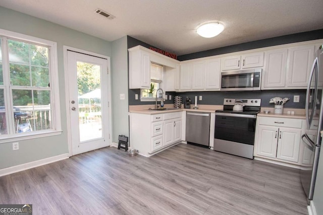 50 Carthedge Trce, Newnan, GA 30263 - kitchen with a sink, visible vents, light countertops, white cabinets, and appliances with stainless steel finishes