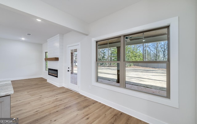 unfurnished living room with a fireplace and light hardwood / wood-style flooring