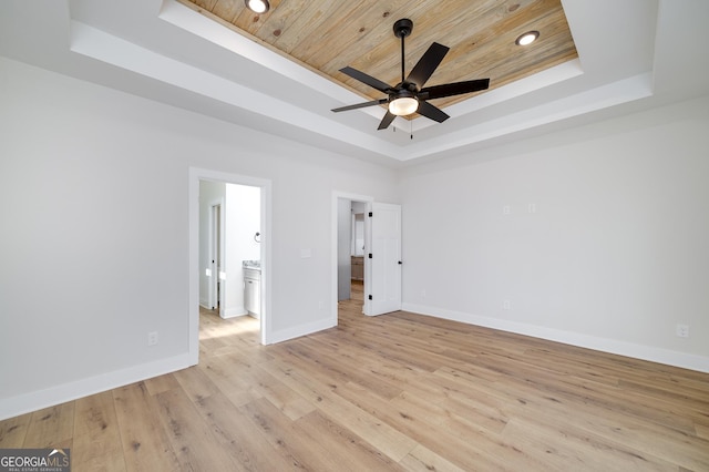 unfurnished bedroom with light hardwood / wood-style floors, wood ceiling, ceiling fan, and a raised ceiling