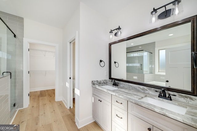 bathroom featuring wood-type flooring, a shower with door, and vanity