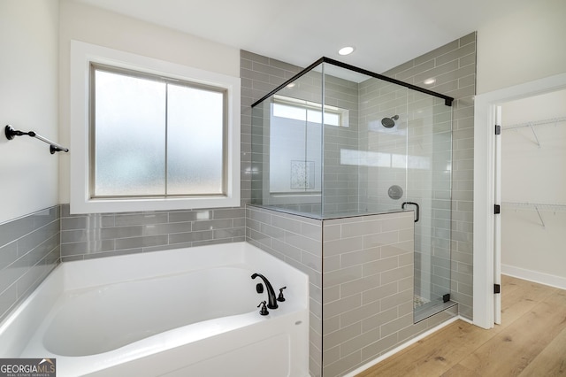 bathroom featuring hardwood / wood-style floors and plus walk in shower