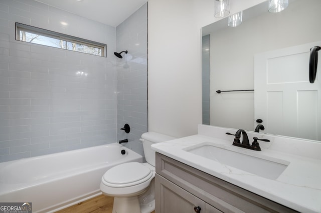 full bathroom with vanity, toilet, tiled shower / bath combo, and wood-type flooring