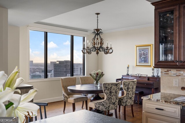 dining room featuring hardwood / wood-style floors, a notable chandelier, and crown molding