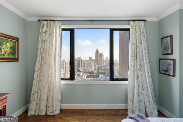 interior space with a view of city, baseboards, crown molding, and wood finished floors