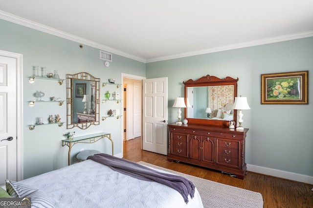 bedroom featuring dark wood-type flooring, visible vents, crown molding, and baseboards