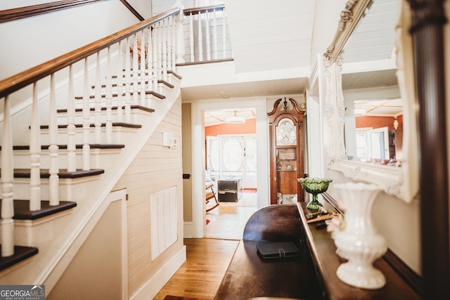 staircase with hardwood / wood-style flooring and wood walls