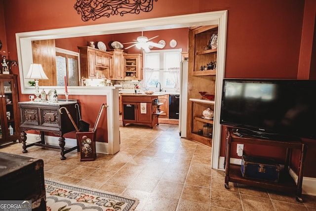 interior space with decorative backsplash, sink, dishwasher, and ceiling fan