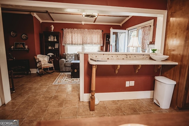 kitchen featuring a kitchen breakfast bar, kitchen peninsula, crown molding, and tile patterned flooring