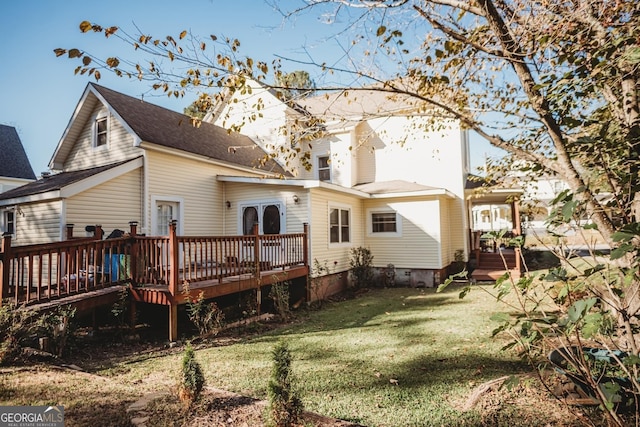 back of property featuring a wooden deck and a yard