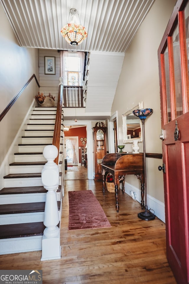 foyer featuring hardwood / wood-style flooring and vaulted ceiling