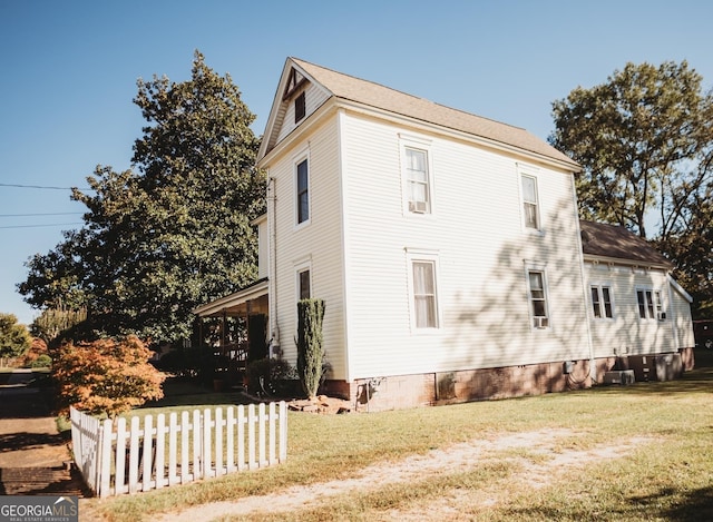 view of side of home with a yard