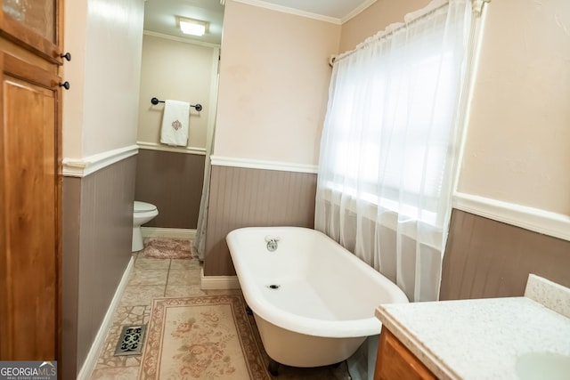 bathroom featuring a tub to relax in, toilet, wooden walls, vanity, and ornamental molding