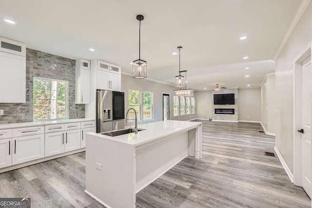 kitchen with white cabinetry, stainless steel refrigerator with ice dispenser, sink, and plenty of natural light