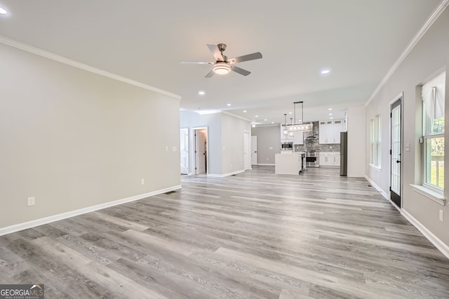 unfurnished living room with ceiling fan, light hardwood / wood-style flooring, and ornamental molding