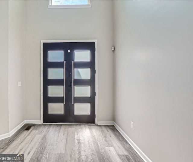 foyer featuring wood-type flooring and french doors