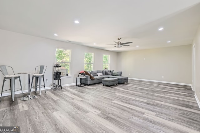 living room with light wood-type flooring and ceiling fan