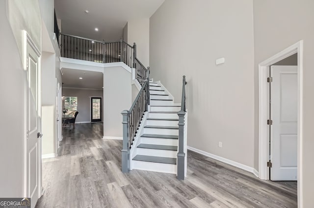 entryway featuring a towering ceiling and light wood-type flooring