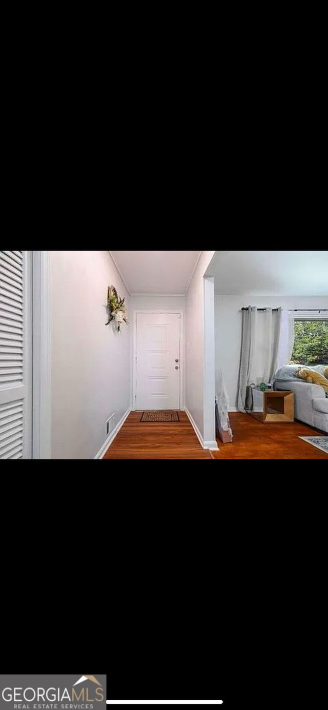 corridor with hardwood / wood-style flooring