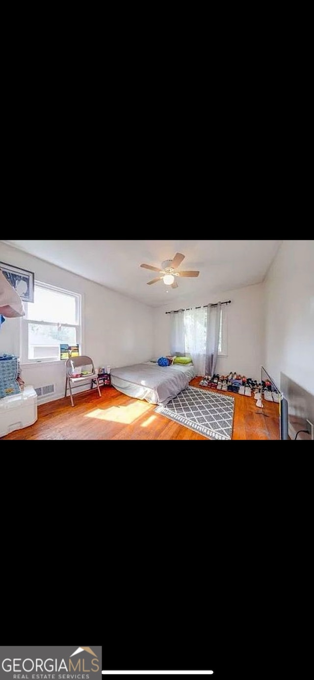 unfurnished bedroom featuring hardwood / wood-style floors and ceiling fan