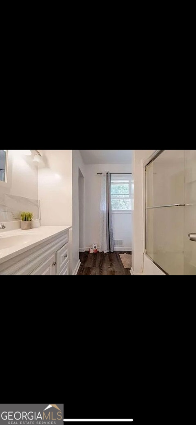 bathroom with vanity, walk in shower, and hardwood / wood-style floors