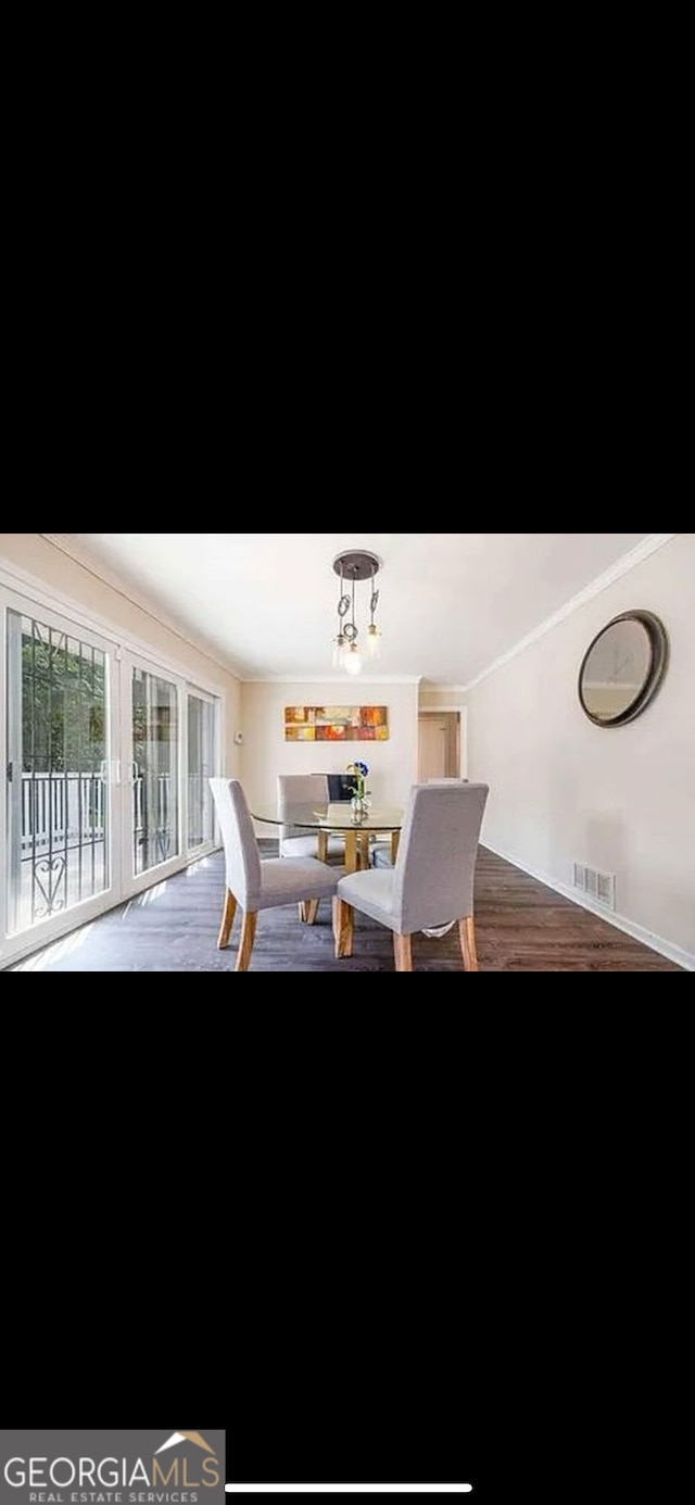 dining area with an inviting chandelier, wood-type flooring, and crown molding