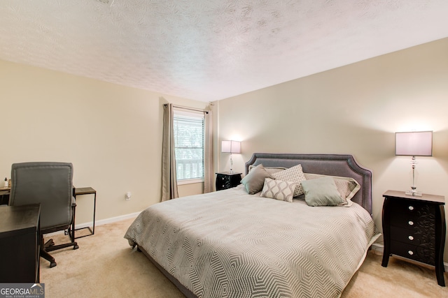 bedroom featuring a textured ceiling and light colored carpet